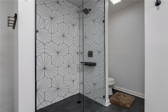 bathroom featuring tile patterned flooring, tiled shower, and toilet