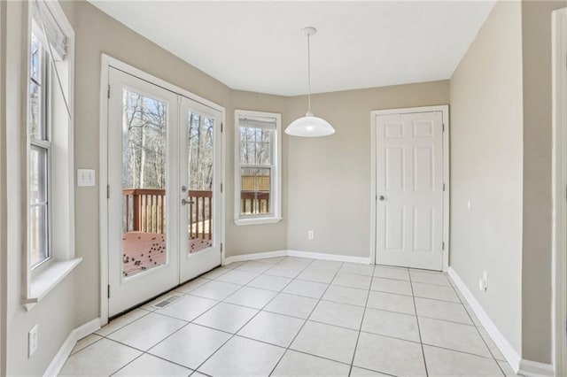 unfurnished dining area featuring light tile patterned flooring and french doors