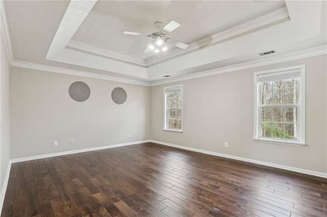 spare room with a tray ceiling, crown molding, ceiling fan, and dark hardwood / wood-style floors