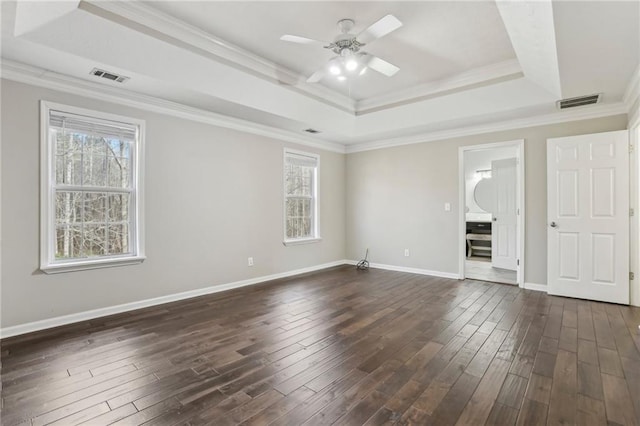 spare room with dark hardwood / wood-style floors, a raised ceiling, and ceiling fan