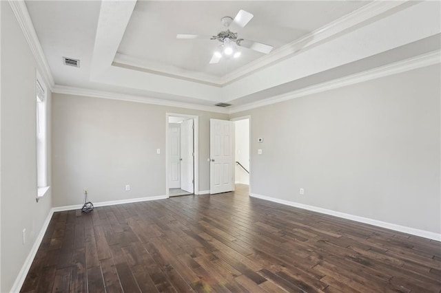 empty room with a raised ceiling, ceiling fan, crown molding, and dark hardwood / wood-style floors