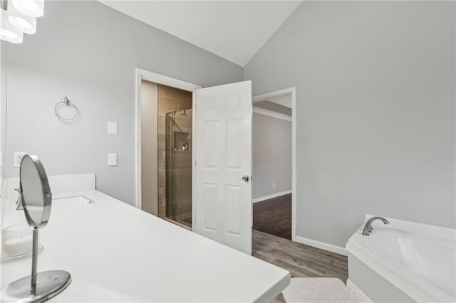 bathroom featuring separate shower and tub, hardwood / wood-style floors, vanity, and lofted ceiling