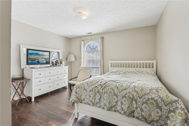 bedroom featuring dark hardwood / wood-style flooring and a textured ceiling