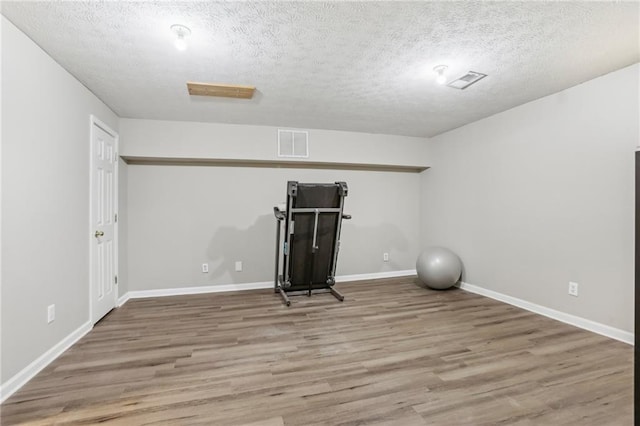 workout room featuring hardwood / wood-style flooring and a textured ceiling