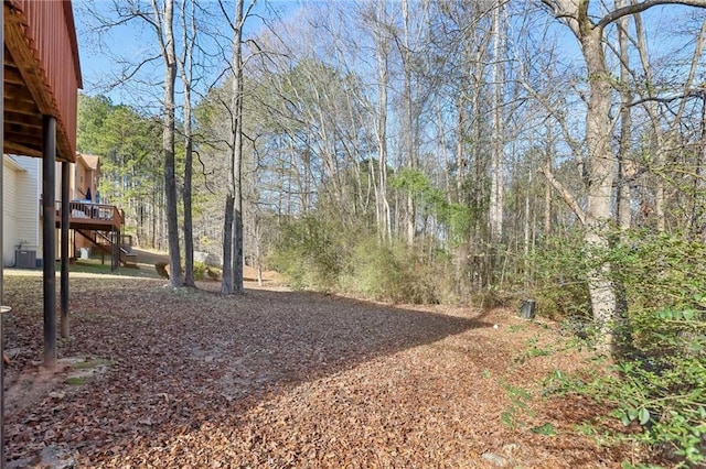 view of yard with a wooden deck and central AC unit