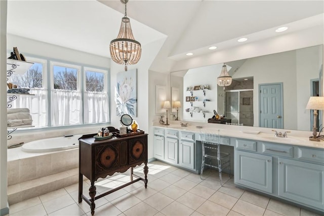 5807 Peacock Ln, Hoschton, GA 30548 - full bathroom featuring lofted ceiling, double vanity, a shower stall, a garden tub, and a chandelier