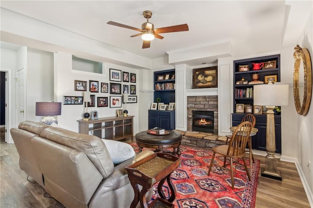 5807 Peacock Ln, Hoschton, GA 30548 - living area featuring a fireplace, baseboards, a ceiling fan, and wood finished floors
