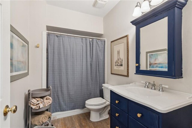 5807 Peacock Ln, Hoschton, GA 30548 - full bath with vanity, toilet, wood finished floors, and visible vents