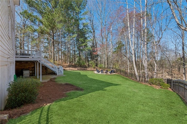 5807 Peacock Ln, Hoschton, GA 30548 - view of yard featuring stairway, a fenced backyard, a fire pit, and a wooden deck