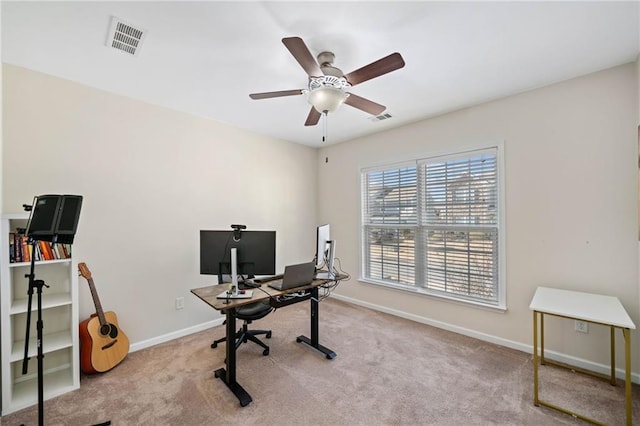 carpeted office space featuring ceiling fan