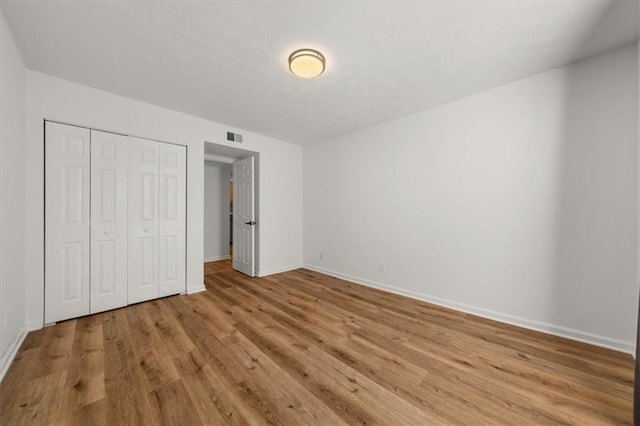 unfurnished bedroom featuring a closet and light wood-type flooring