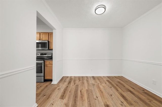 kitchen featuring crown molding, appliances with stainless steel finishes, a textured ceiling, and light wood-type flooring