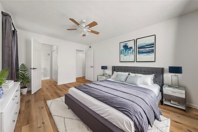 bedroom with ensuite bath, light hardwood / wood-style floors, and ceiling fan