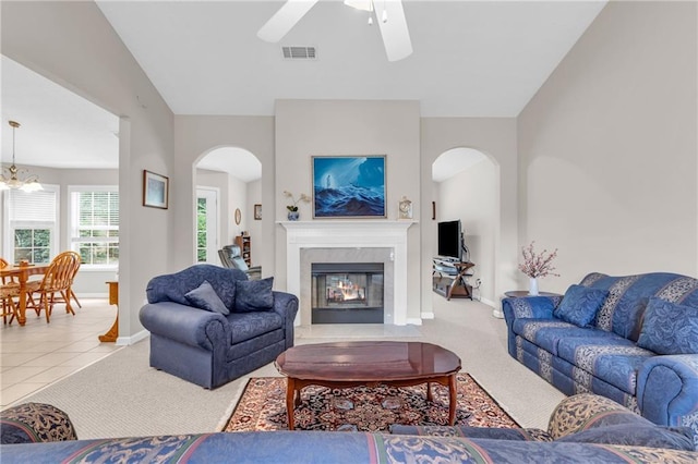 1530 Brisbane Dr, Dacula, GA 30019 - carpeted living area with arched walkways, a ceiling fan, a premium fireplace, and a chandelier