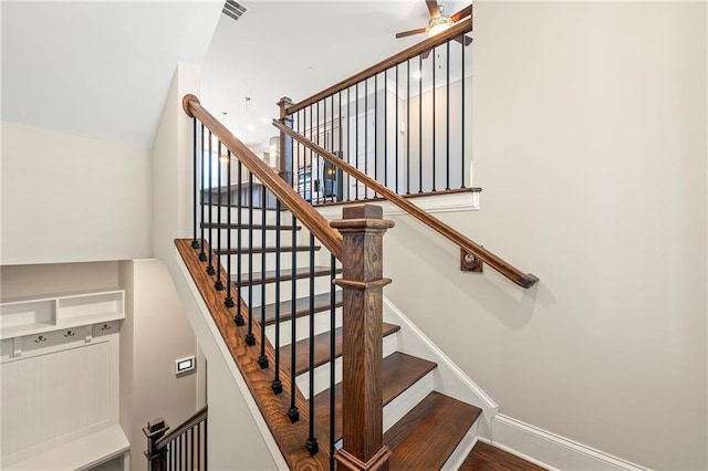 stairs with visible vents, a ceiling fan, and baseboards