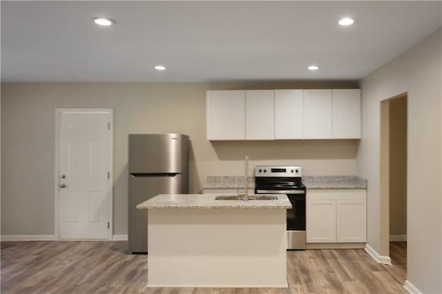 kitchen featuring appliances with stainless steel finishes, a kitchen island with sink, light hardwood / wood-style floors, and white cabinetry