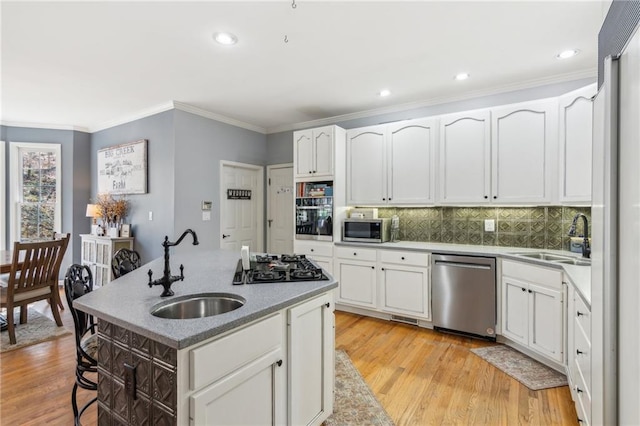 kitchen featuring light wood finished floors, a sink, and stainless steel appliances