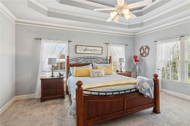 bedroom with light carpet, ornamental molding, and a raised ceiling