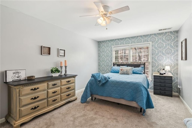 bedroom featuring light carpet, baseboards, visible vents, and wallpapered walls
