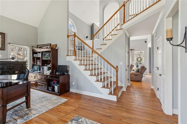 office area with a high ceiling, baseboards, and wood finished floors