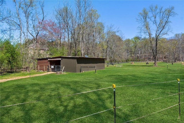 surrounding community with a lawn, fence, a pole building, and an outdoor structure
