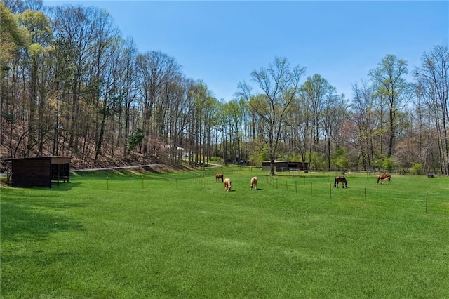 surrounding community with fence and a yard