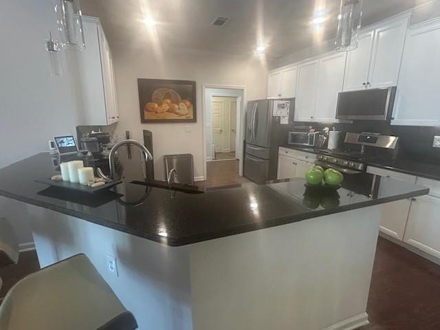 3311 Lindenridge Dr, Buford, GA 30519 - kitchen with appliances with stainless steel finishes, dark countertops, and white cabinetry