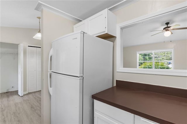 354 Henry Aaron Ave SW, Atlanta, GA 30310 - kitchen featuring freestanding refrigerator, dark countertops, light wood-style floors, white cabinets, and ornamental molding