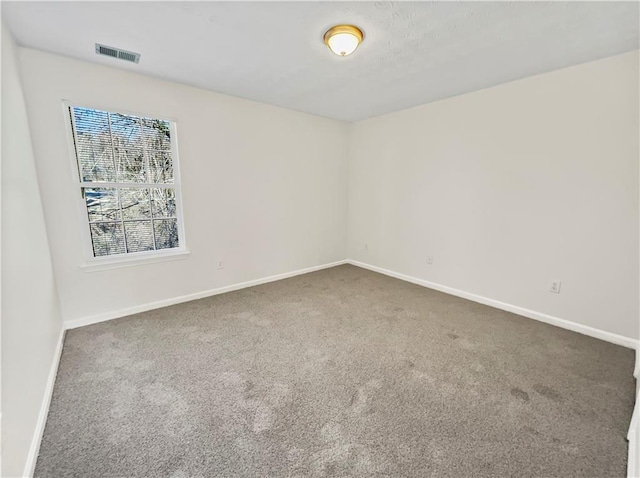 spare room featuring visible vents, baseboards, and carpet flooring