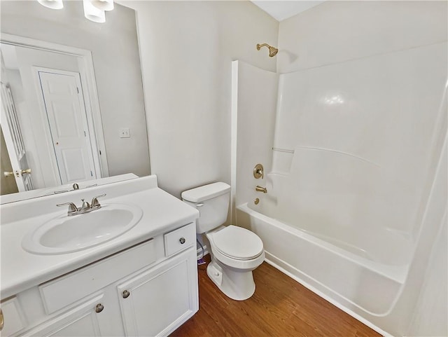 full bath with shower / tub combination, vanity, toilet, and wood finished floors