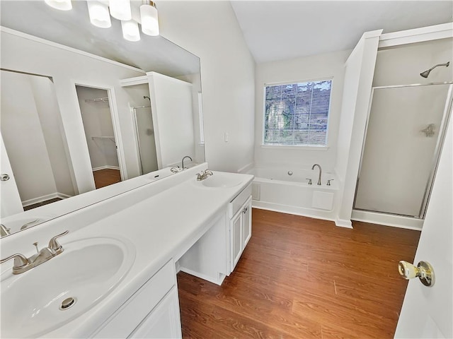 full bath featuring a garden tub, wood finished floors, a sink, and a shower stall