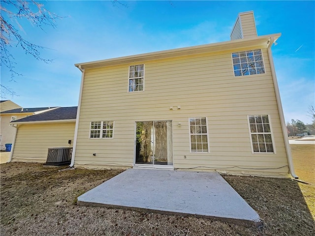 back of house with a patio, central AC, and a chimney