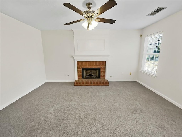 unfurnished living room featuring a brick fireplace, carpet flooring, visible vents, and baseboards