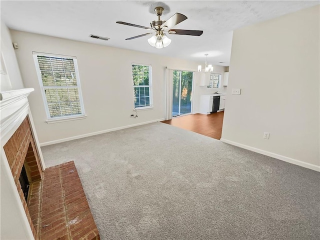 unfurnished living room with carpet flooring, a fireplace, visible vents, and baseboards