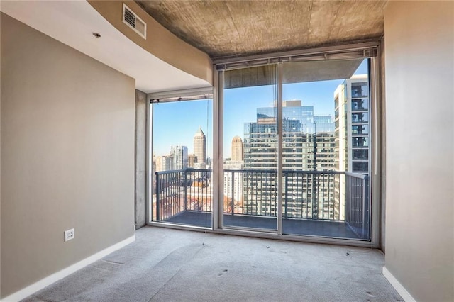 unfurnished room featuring carpet flooring, floor to ceiling windows, and a healthy amount of sunlight