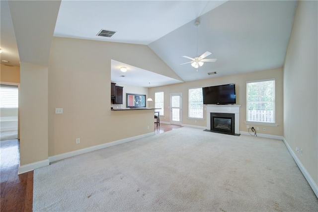 1575 Parkside Village Dr, Cumming, GA 30040 - unfurnished living room featuring ceiling fan, vaulted ceiling, baseboards, a fireplace with flush hearth, and carpet floors