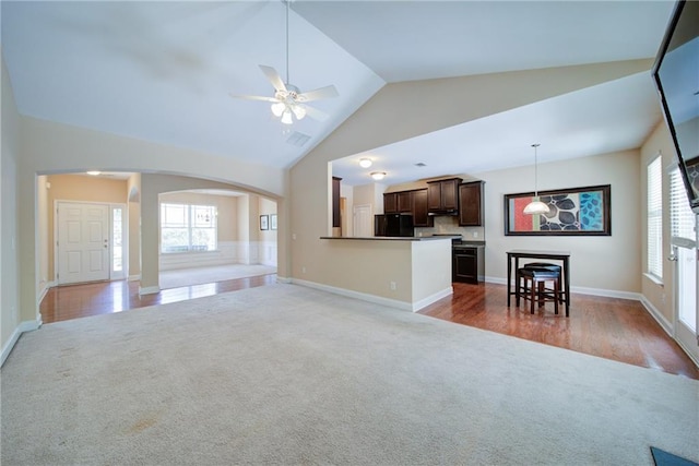 1575 Parkside Village Dr, Cumming, GA 30040 - carpeted living room with lofted ceiling, arched walkways, a ceiling fan, plenty of natural light, and baseboards