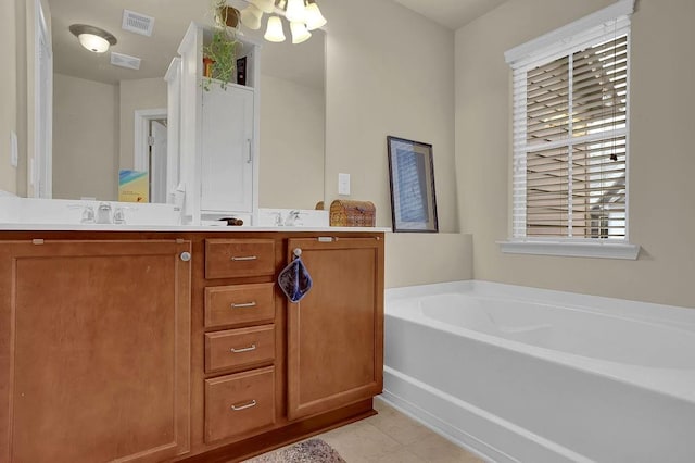full bathroom featuring a chandelier, vanity, a bath, tile patterned floors, and visible vents