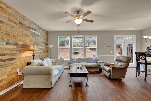living area featuring dark wood-style floors, ceiling fan, and a healthy amount of sunlight
