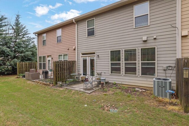 rear view of property with a patio, fence, a yard, and central AC