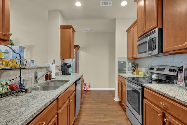 kitchen with a sink, visible vents, stainless steel appliances, and baseboards