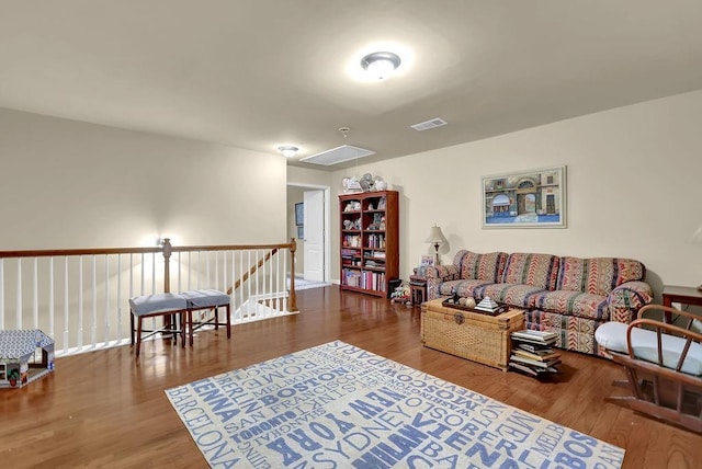 living area featuring attic access, wood finished floors, and visible vents