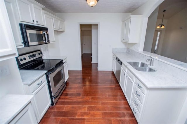 kitchen with a sink, light countertops, dark wood-style flooring, and stainless steel appliances