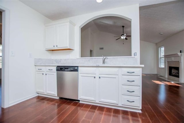 kitchen featuring a fireplace with flush hearth, a sink, light countertops, and stainless steel dishwasher