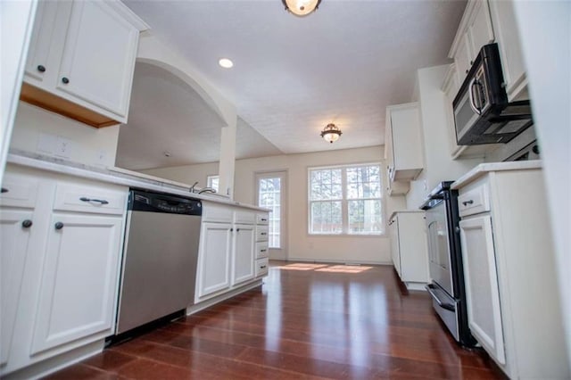 kitchen featuring white cabinetry, light countertops, dark wood-type flooring, and appliances with stainless steel finishes