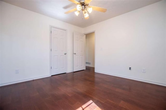 unfurnished room featuring visible vents, baseboards, wood finished floors, and a ceiling fan