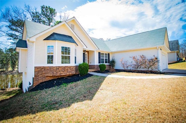 view of front of property with stone siding, an attached garage, and a front lawn