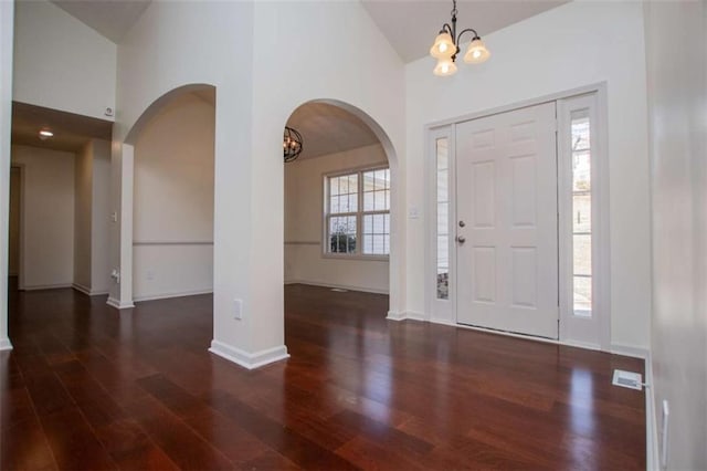 foyer featuring wood finished floors, visible vents, a wealth of natural light, and baseboards