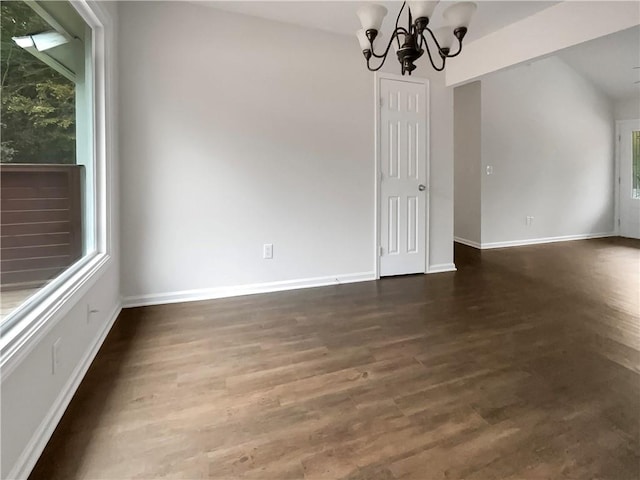 unfurnished dining area with an inviting chandelier and dark hardwood / wood-style flooring