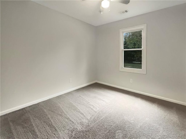 empty room with dark colored carpet and ceiling fan